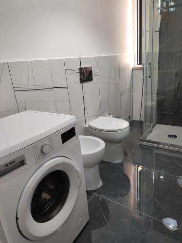 a bathroom with a washing machine and a toilet at Oniria Suite - 100 mt dal mare in Terracina