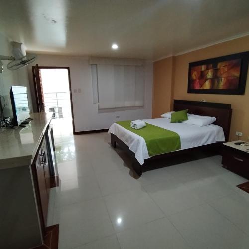 a hotel room with a bed and a television at Hotel El Bosque Valledupar in Valledupar