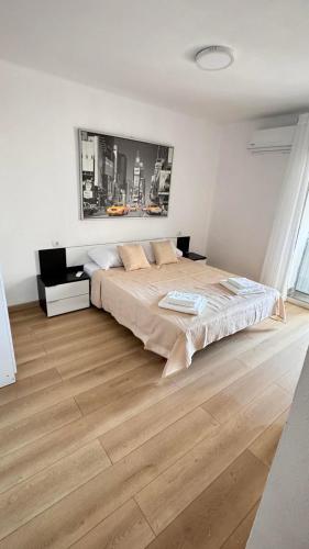 a bedroom with a large bed and a wooden floor at Aly Home in Castellón de la Plana