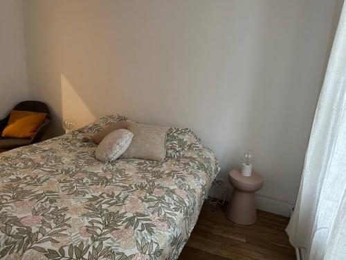 une chambre avec un lit avec des oreillers dessus dans l'établissement Maison chaleureuse Marsannay la Cote, à Marsannay-la-Côte