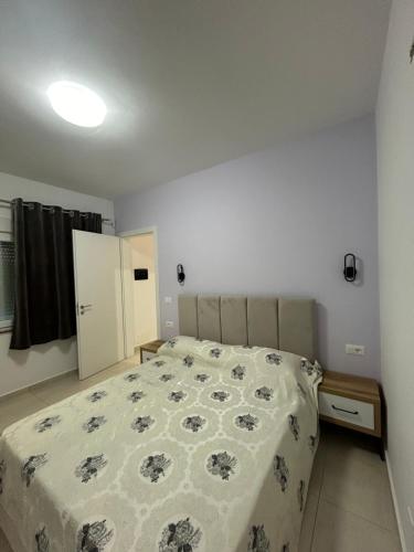 a bedroom with a bed with a floral bedspread at Sol Apartments in Lezhë
