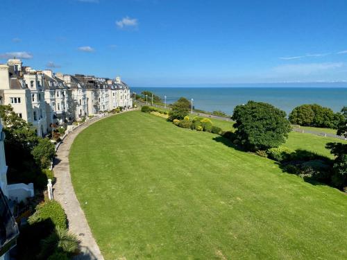 a large green field with buildings and the ocean at Clifton Views in Folkestone
