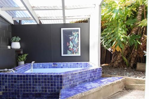 eine blaue geflieste Wanne mitten in einem Innenhof in der Unterkunft Hinemoa Haven in Rotorua