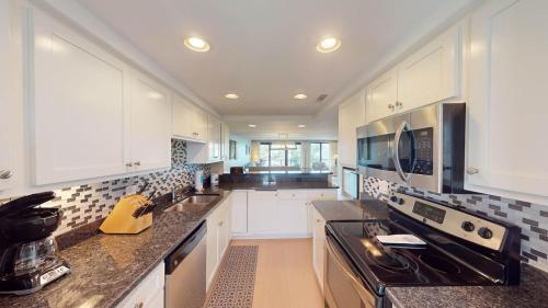 a kitchen with white cabinets and a stove top oven at CoastalRetreat Beachfront 3BR Litchfield By theSea in Pawleys Island