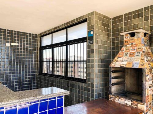 una cucina piastrellata con camino e finestra di Apê perfeifo na Ponta Verde a Maceió