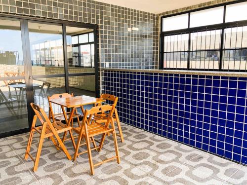 tavolo e sedie in una stanza con piastrelle blu di Apê perfeifo na Ponta Verde a Maceió