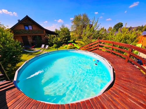 a large swimming pool on a wooden deck at Siedlisko na Wzgórzu - Noclegi Agroturystyka - Borsuki in Sarnaki