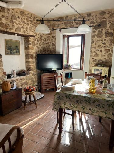 a living room with a table and a tv at La Raganella D'Oro in Pico