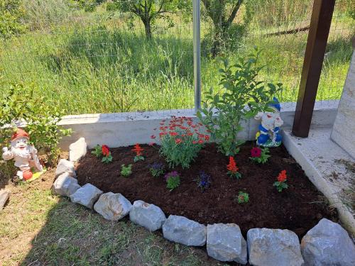 a garden with a plant in a flower bed at Μονοκατοικία Kathrin in Nea Kalikratia