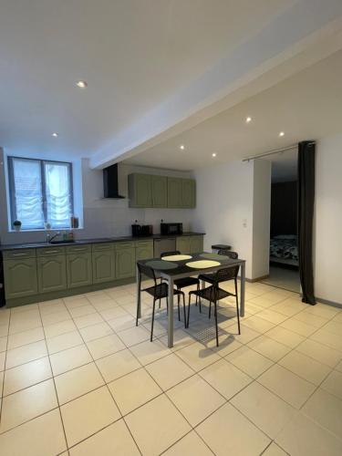 - une cuisine avec deux tables et des chaises dans l'établissement Maisonnette rénovée, à Villy-en-Trodes