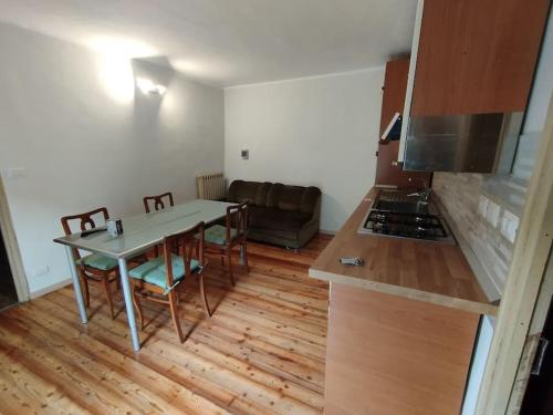 a kitchen with a table and a couch in a room at La Casa della Gerla in Viù