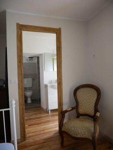 a chair in front of a mirror in a bathroom at La Casa della Gerla in Viù