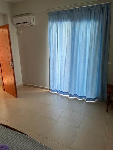 a room with a blue curtain and a white floor at Vila Rapo in Himare