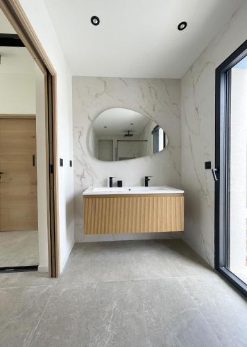 une salle de bain avec un lavabo et un miroir dans l'établissement VILLA BAYA - 800 m de la plage, au Cap d'Agde