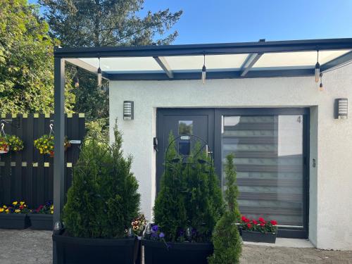 a garage with a black door and some plants at Ferienwohnung E in Soltau