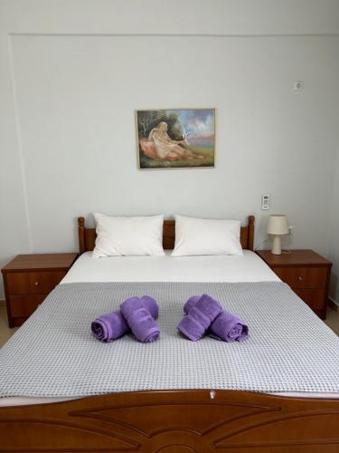 a bed with purple pillows on top of it at Vila Rapo in Himare