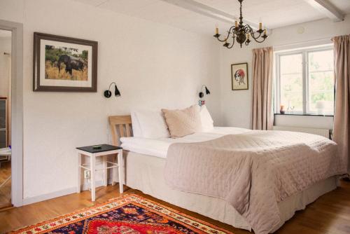 a bedroom with a large bed and a chandelier at Karnelund Krog & Rum in Simrishamn