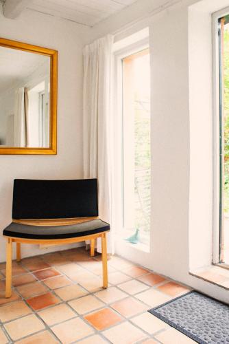 a bench in a room with a mirror and a window at Karnelund Krog & Rum in Simrishamn