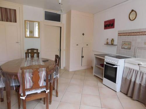 - une cuisine avec une table, une table et une cuisinière dans l'établissement MAISON entre CREUSE et BERRY, à Badecon-le-Pin