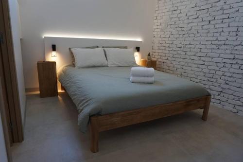 une chambre avec un lit avec un mur de briques dans l'établissement -NotreFrenchCasa- Appart avec terrace proche Disney, Paris & Reims, à La Ferté-sous-Jouarre