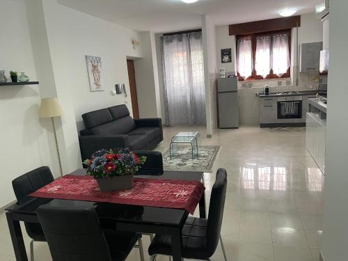 un soggiorno con tavolo e divano e una cucina di Casa Pontina vicino OSPEDALE ICOT a Latina