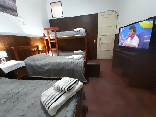 a hotel room with two beds and a flat screen tv at C'Aroma de Mujer in San Salvador de Jujuy