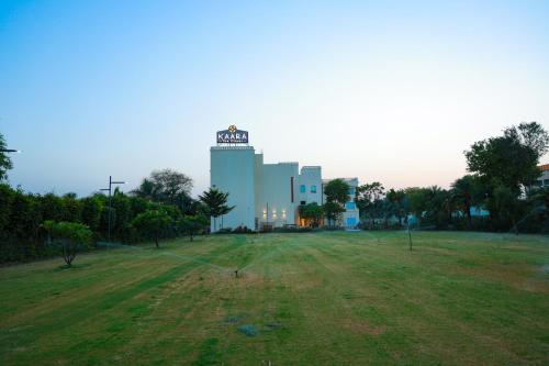 a large building with a field in front of it at Kaara Gurgaon in Gurgaon