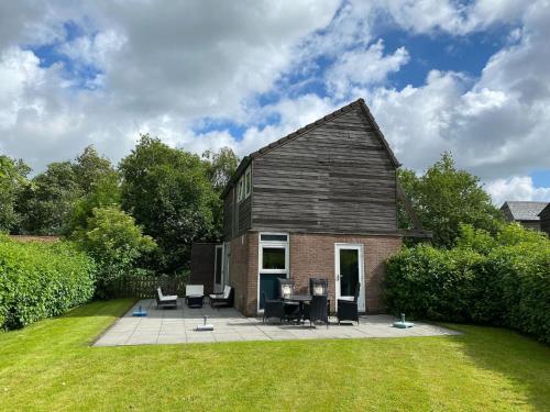 a house with a patio with a table and chairs at Holiday Home in Grou near Frisian Lakes in Grou