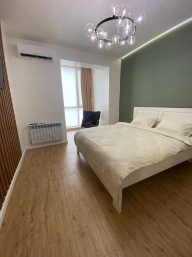 リウネにあるАпартаменти на Чорновола,поруч Щасливеの大きなベッドとシャンデリアのある寝室