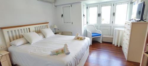 a bedroom with a bed with two stuffed animals on it at Rincón del Mar, Mundaka in Mundaka
