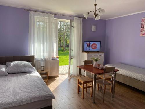 ein Schlafzimmer mit Bett und Tisch und ein Esszimmer in der Unterkunft Holiday Home Sieroslaw near Baltic Sea in Sierosław