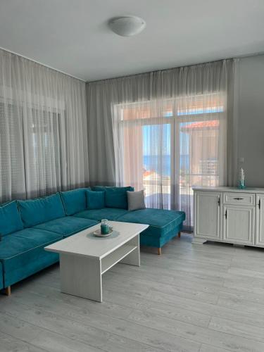 a living room with a blue couch and a table at Вила in Asprovalta