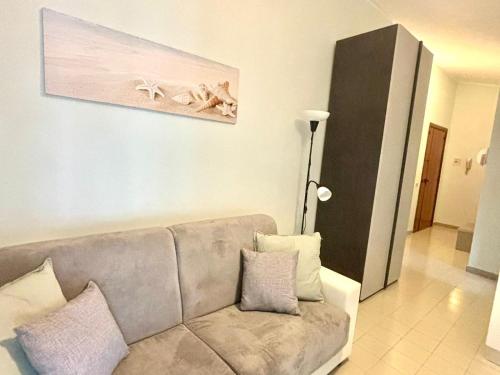 Una sala de estar con un sofá y un cuadro en la pared. en Summer House, en Agropoli