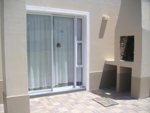 una puerta corredera de cristal que da a un patio con ventana en Waterside Living CL07, en Jeffreys Bay