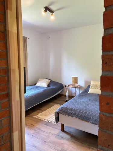 a bedroom with two beds and a table at Słona Fala in Sianozety