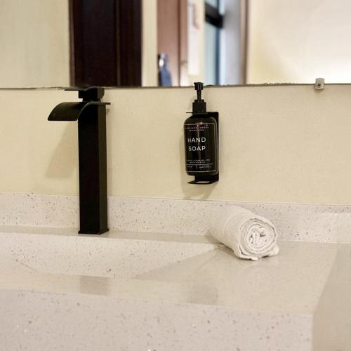 a bathroom sink with a soap bottle on the counter at Morrison Hotel San Salvador in San Salvador
