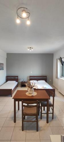 a room with two beds and a table and a bed at KANALI HOLIDAYS APARTMENT 4 in Kanali