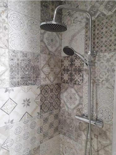 une douche dans une salle de bain avec un mur carrelé dans l'établissement Magnifique T2 jacuzzi piscine, à Fréjus