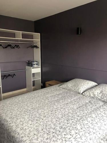 - une chambre avec un lit blanc et un mur violet dans l'établissement Appartement - Vitry sur Seine, à Vitry-sur-Seine