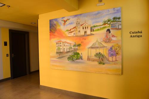 a painting hanging on a wall in a hallway at Brisas Flat Hotel in Cuiabá