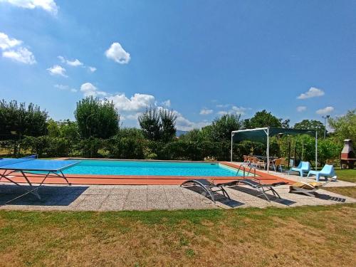 a swimming pool with two tables and two chairs at Villa Cortinella in Marlia