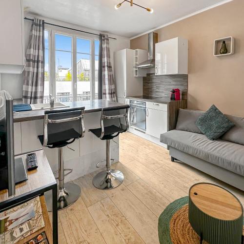 une cuisine et un salon avec un canapé dans l'établissement L'Esprit de Seine, à Asnières-sur-Seine