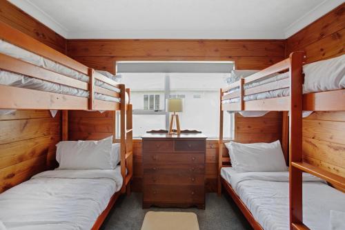 a bedroom with two bunk beds and a desk at Sandy Feet Retreat close to Beach in Clarks Beach