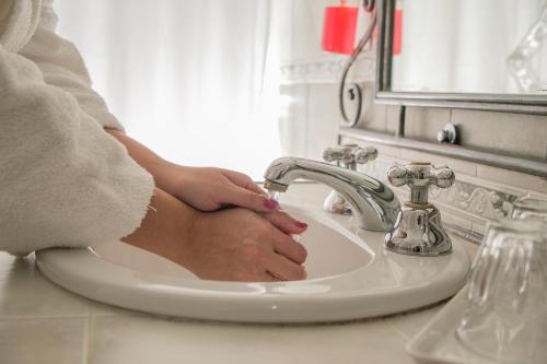 a woman washing her hands in a bathroom sink at Don Numas Posada & Spa in San Lorenzo
