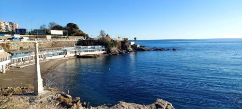 a body of water with a pier and the ocean at Gaslini Sea House in Genova