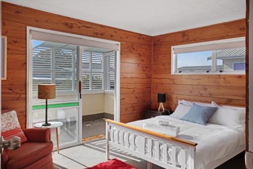 a bedroom with a bed and a window at Sandy Feet Retreat close to Beach in Clarks Beach