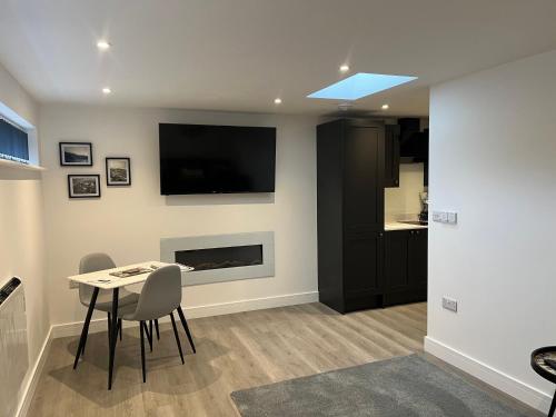 sala de estar con mesa y TV en la pared en THE ARCHERS, en Glastonbury