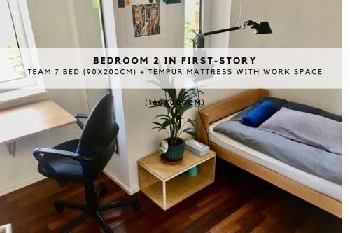 a bedroom with a desk and a bed and a chair at Townhouse with garden, terrace & balcony in Berlin