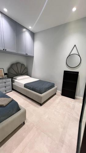 a bedroom with two beds and a dresser and a mirror at D'azur Home in Vlorë