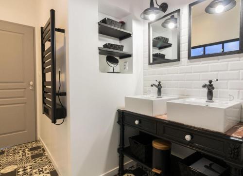 a bathroom with two sinks and a mirror at Gite De Pène Blanque in Arbas